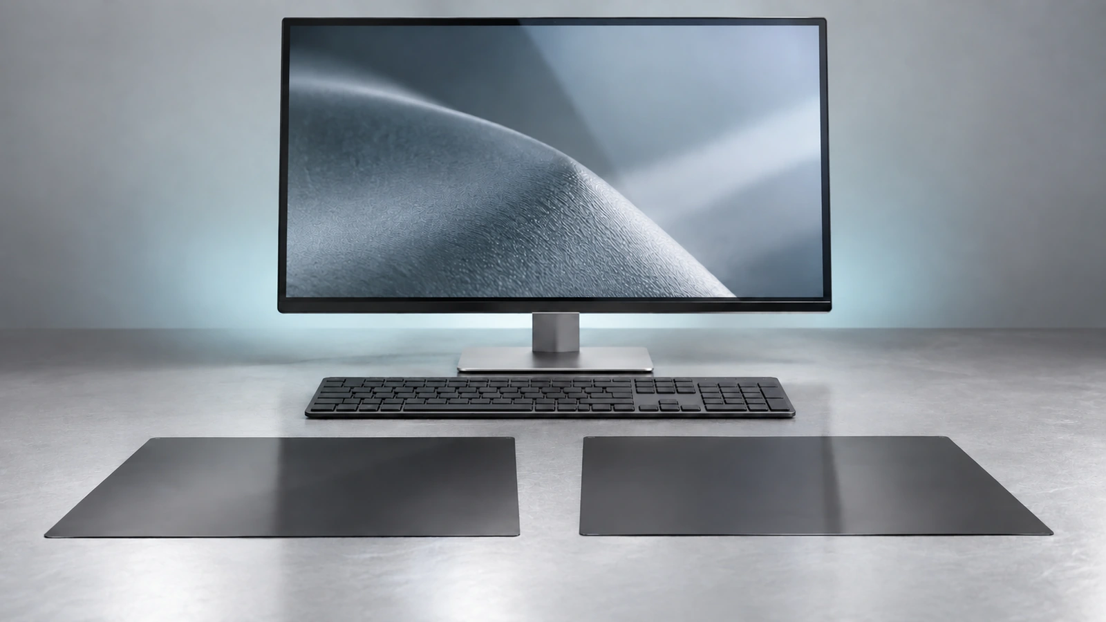 Two separate dark filter samples lie beside each other in front of an unbranded monitor and keyboard.